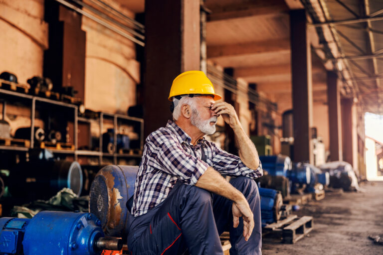 A,Worried,Senior,Factory,Worker,Is,Sitting,Next,To,The